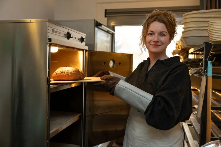 Demi van Vliet haalt een zuurdesembrood uit de oven van haar bakkerij Club Brood in Weesp